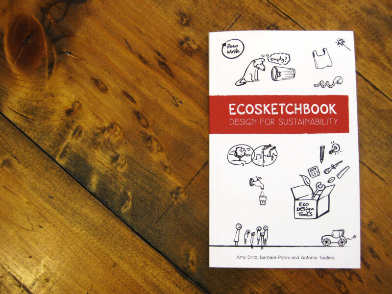 small book on wooden table. Title is Ecosketchbook: Design for Sustainability