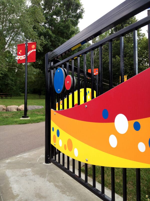 bright colored ribbon graphics on black metal fence
